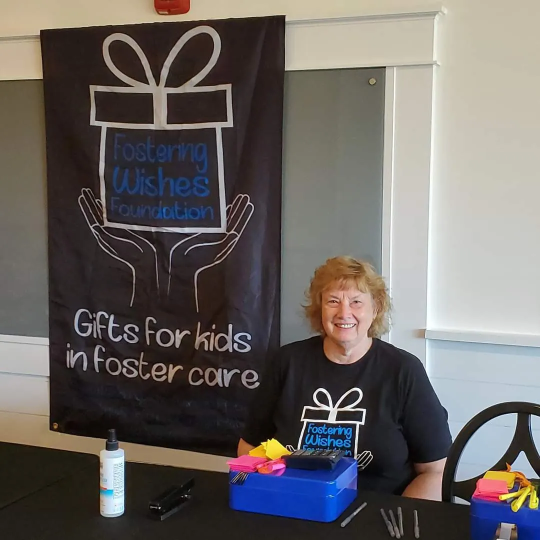A volunteer greeting guests at the registration table for Lunch With a Purpose